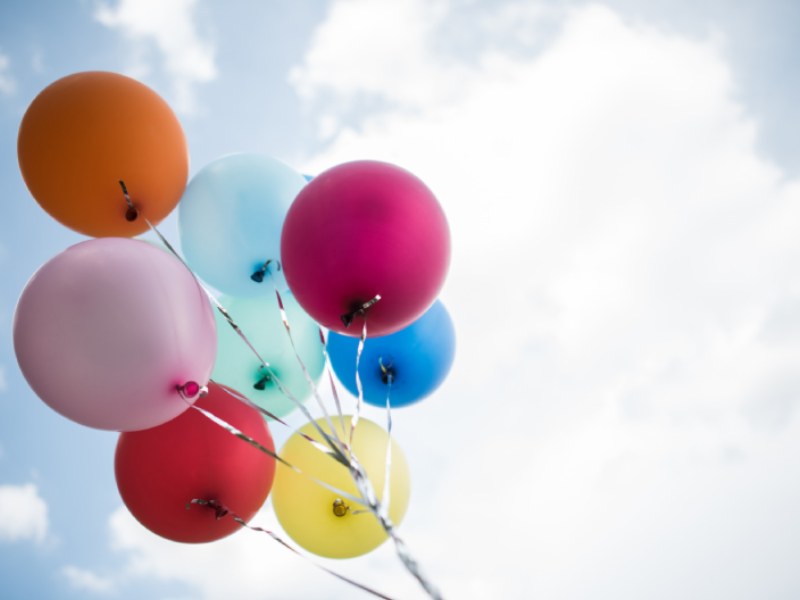 Young girl hand holding colorful balloons